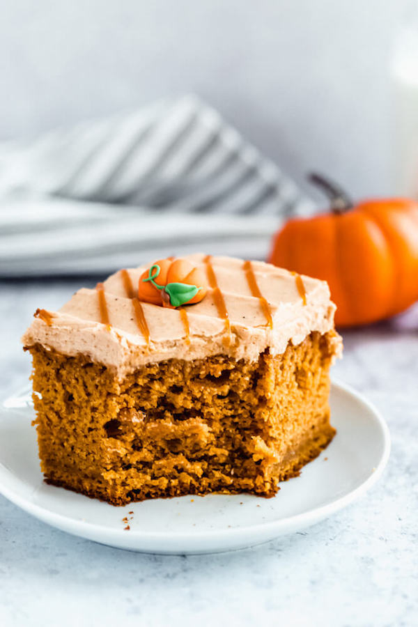 slice of pumpkin cake topped with caramel pumpkin spice cream cheese frosting