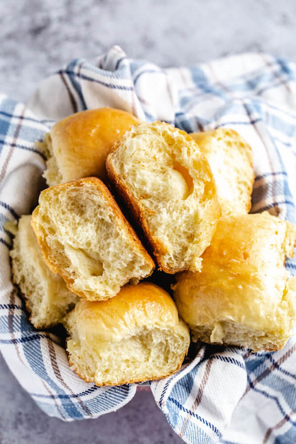 dinner roll cut in half in a towel covered bowl