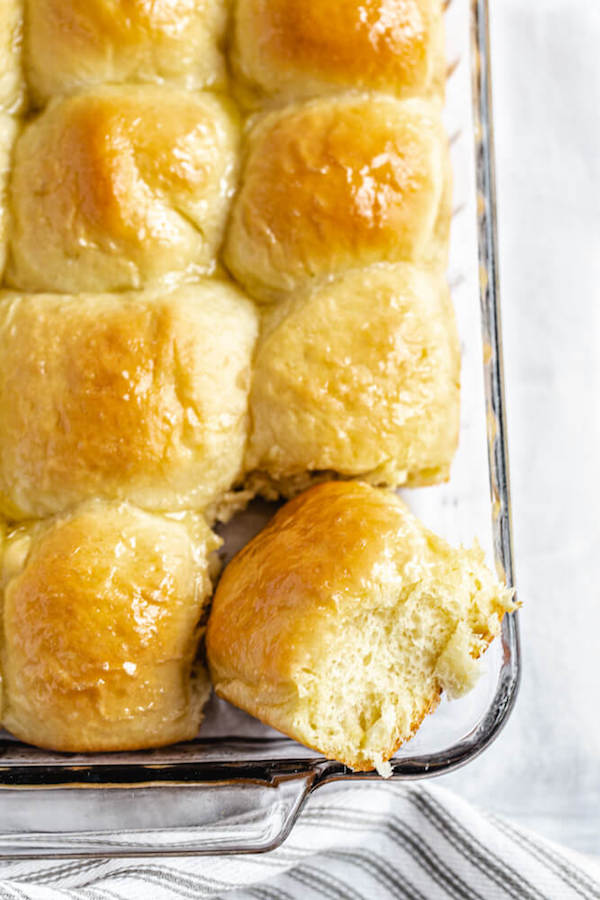 dinner rolls in a baking dish with one facing upwards