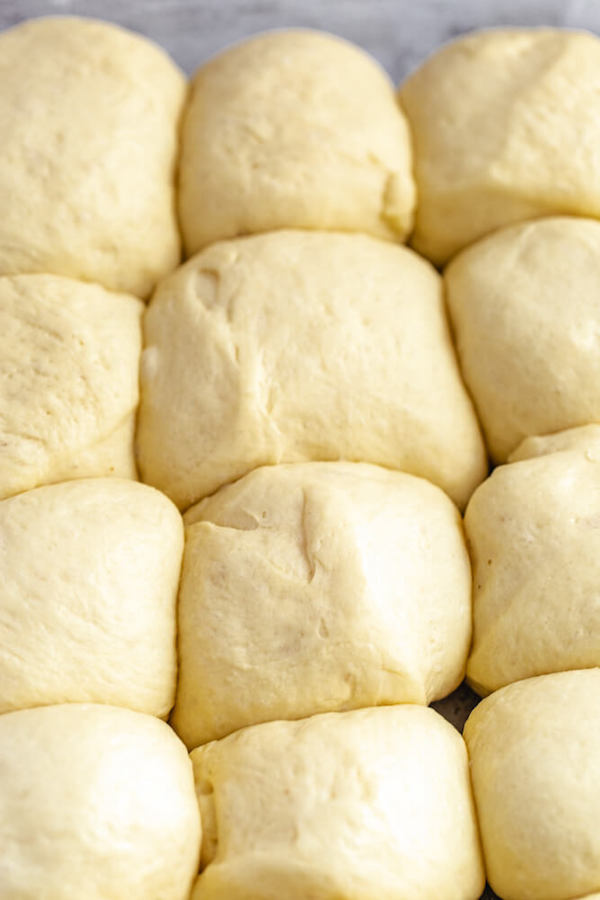 unbaked dinner rolls doubled in size in a baking dish