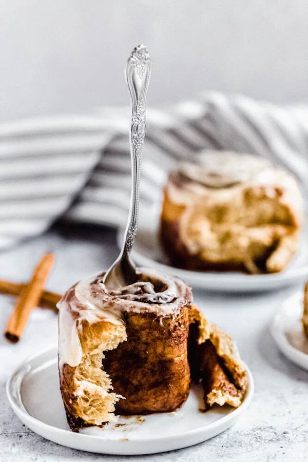 fork stuck into the top of an unraveled cinnamon roll