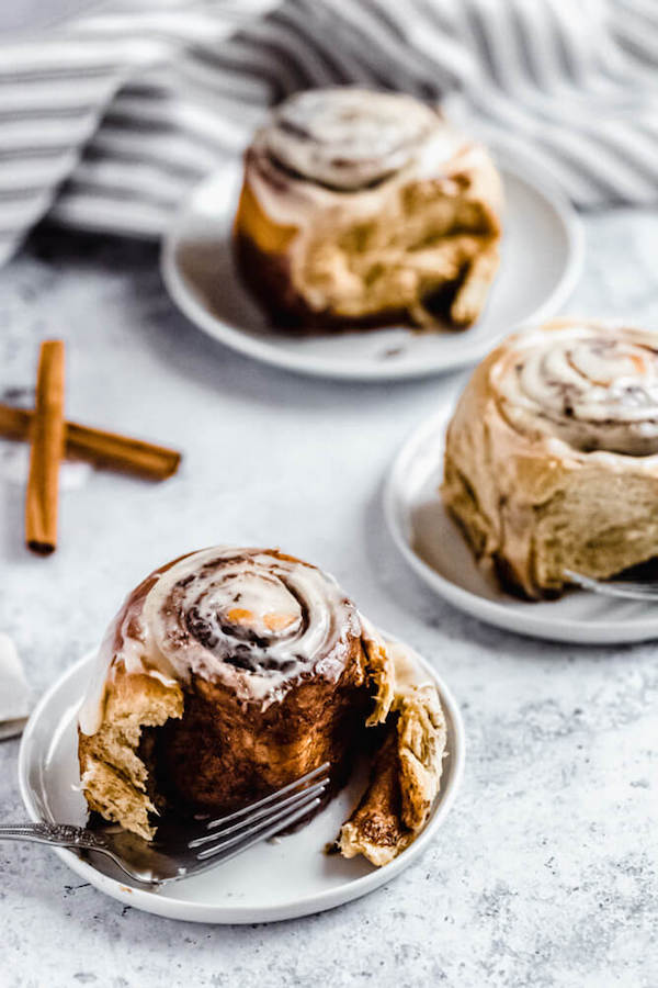 three cinnamon rolls with one half eaten