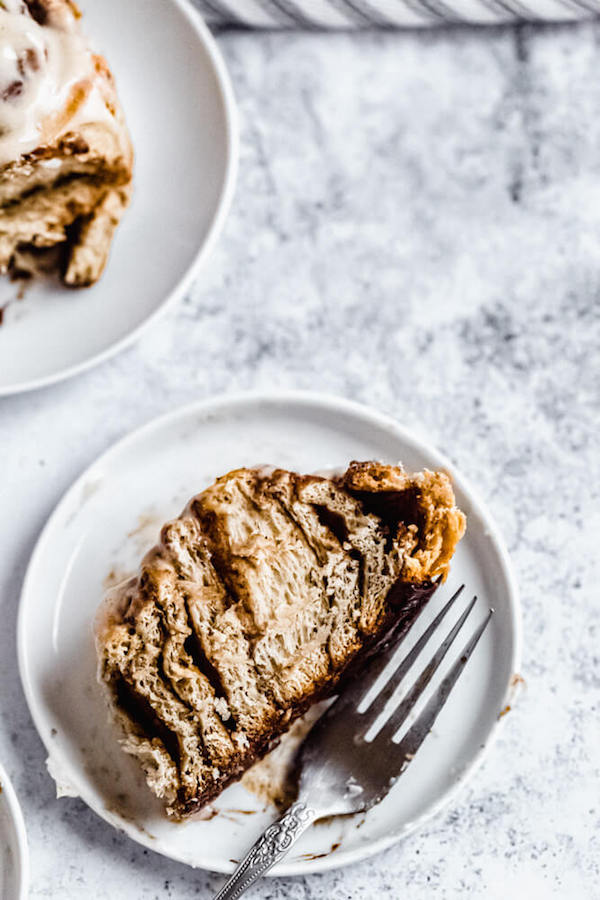 chai cinnamon roll cut in half on an appetizer plate 