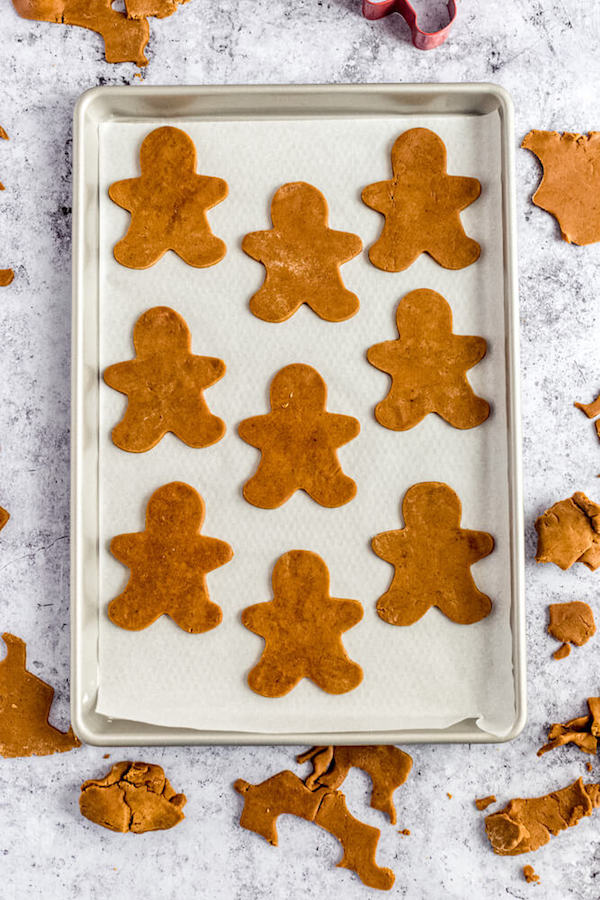 unbaked man shaped cookie dough on parchment lined baking sheet