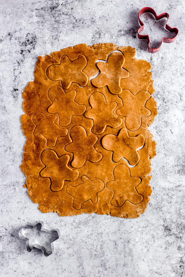 top view of rolled out gingerbread dough with man shaped cutouts