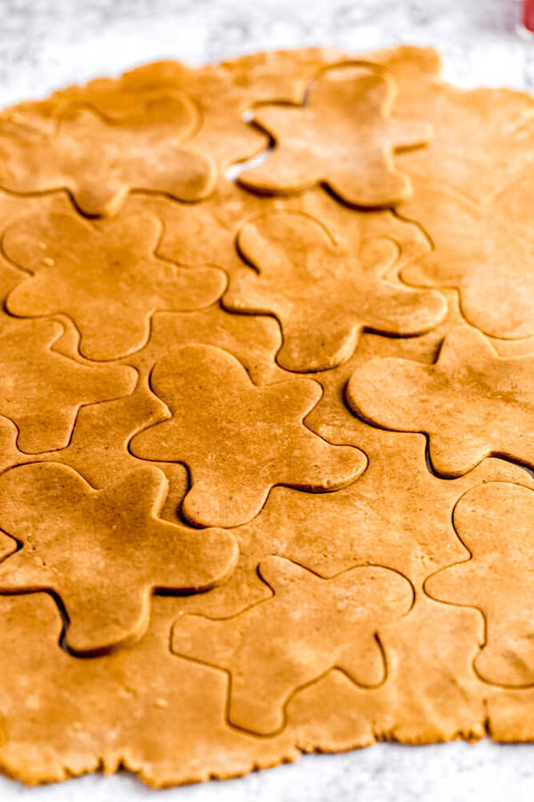 close up of rolled out cookie dough with man shapes cut out