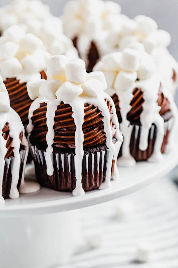 close up side view of hot chocolate cupcakes on a cake stand