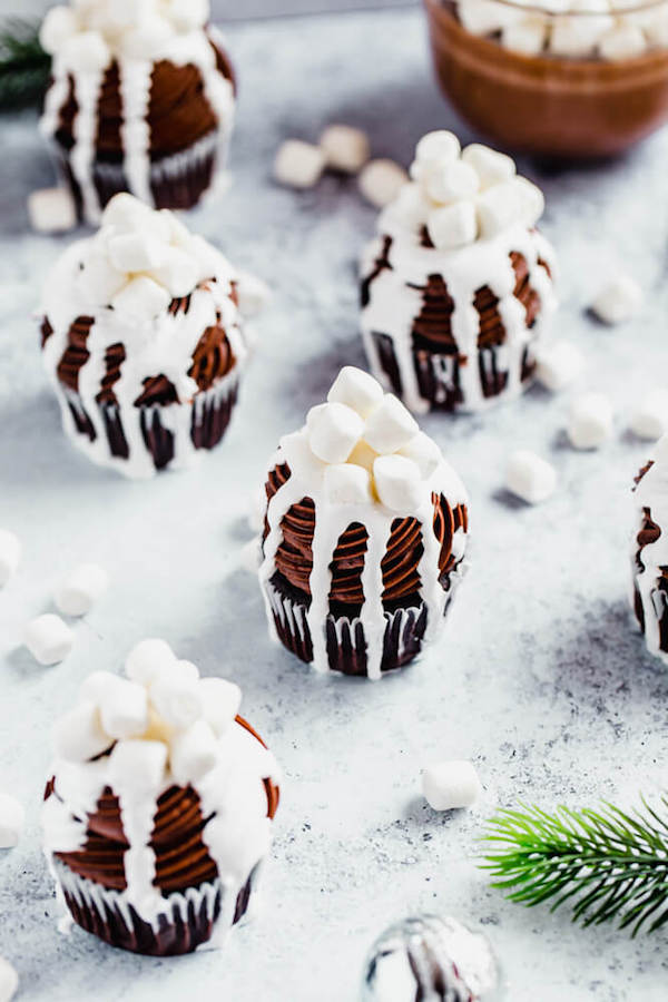 hot chocolate cupcakes with a mug of hot chocolate in the back