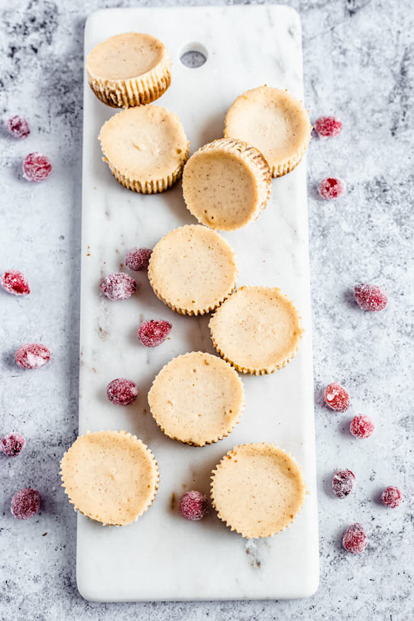 plain mini eggnog cheesecakes and sugared cranberries on a marble board