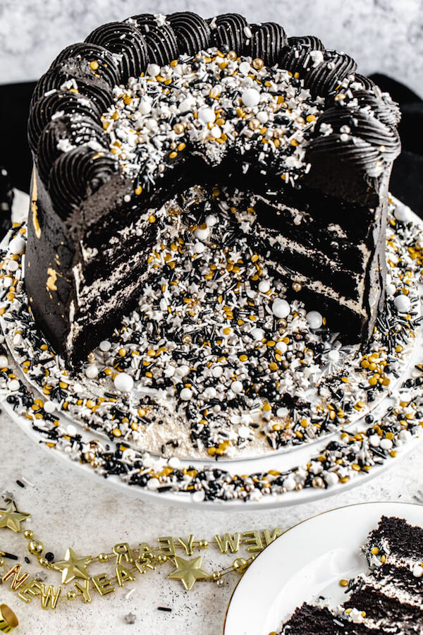 cake cut open with black, silver, gold and white sprinkles spilling out