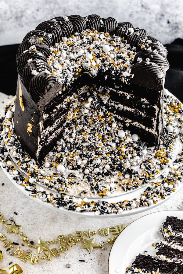 sprinkles pouring out of a sliced black cake