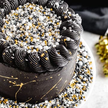 close up of black white silver and gold themed cake