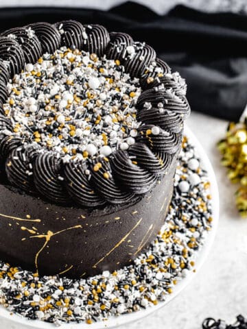 close up of black white silver and gold themed cake