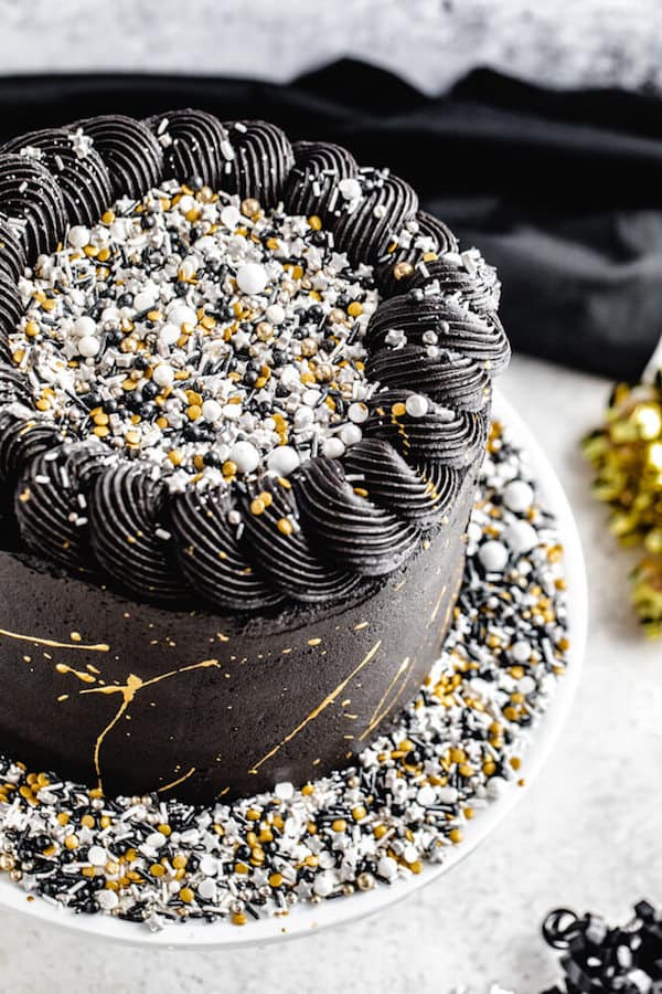 close up of black white silver and gold themed cake