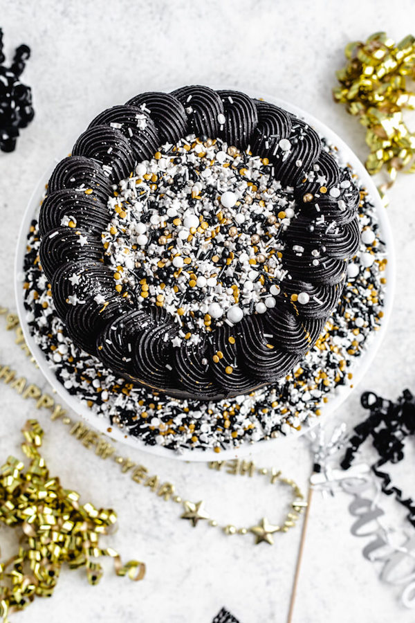 full top view of black cake with sprinkles in centre