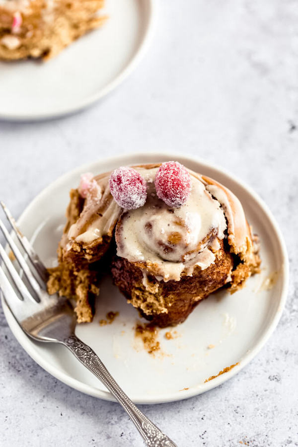 half eaten gingerbread cinnamon roll on an appetizer plate