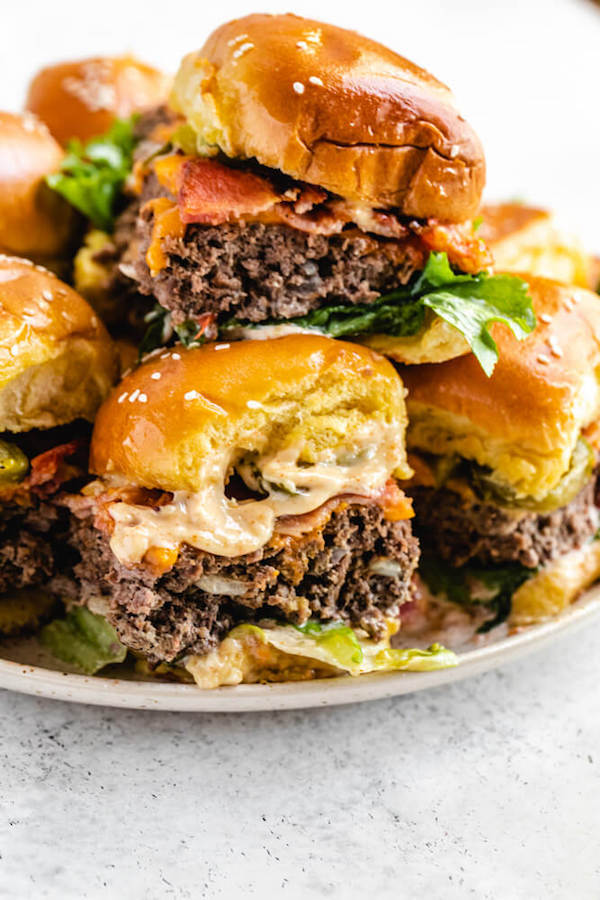 close up of small bacon and cheese burger on a white plate