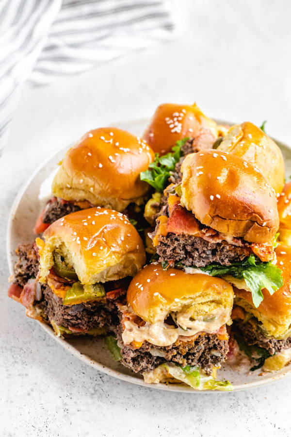 top view of mini cheeseburgers on a large white plate