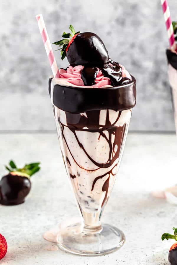 chocolate chip and strawberry milkshake in a milkshake glass