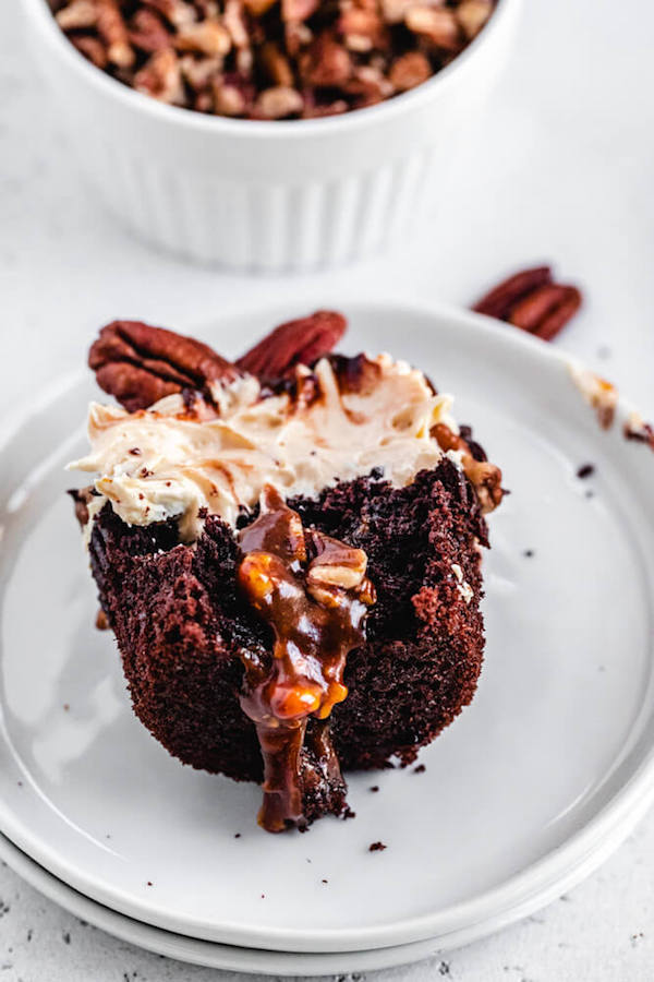 chocolate caramel cupcake with bite taken out of it on a small plate