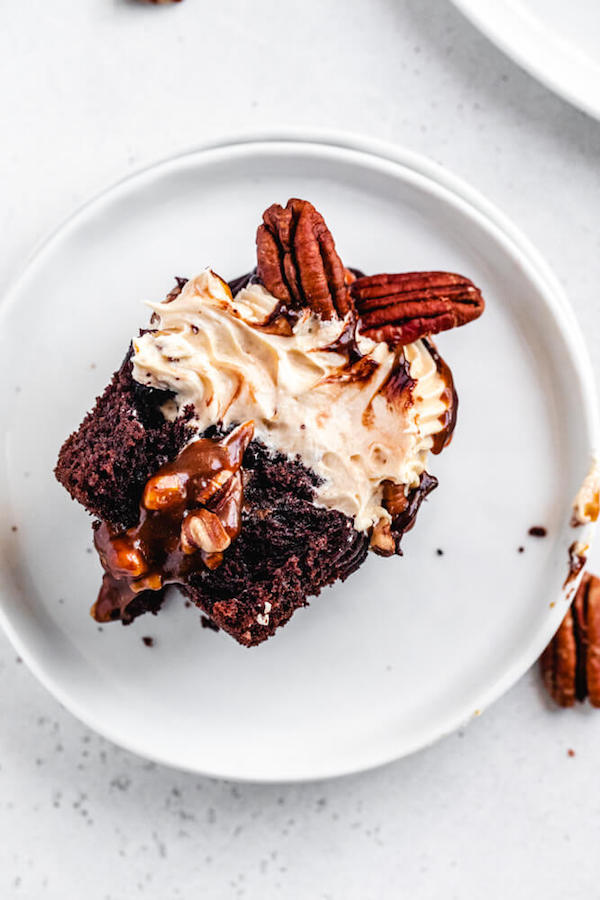 caramel pecan sauce filled chocolate cupcake on a white plate