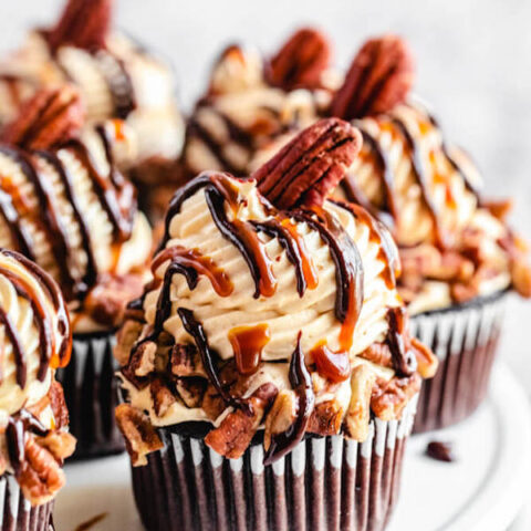 Caramel pecan cupcakes on a white cake stand