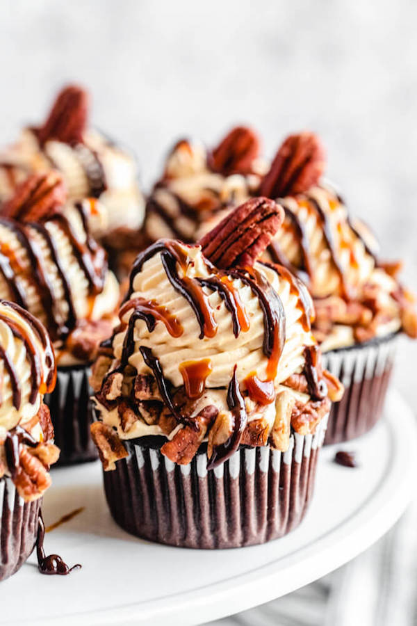 Caramel pecan cupcakes on a white cake stand