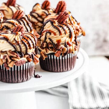 chocolate caramel pecan cupcakes on a white cake stand