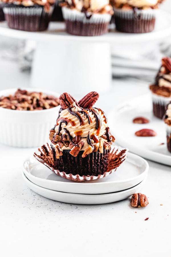 unwrapped turtle cupcake on a stack of white appetizer plates