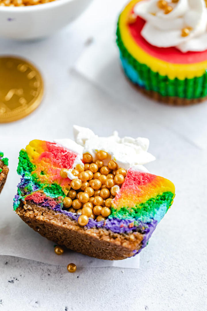 half of a rainbow coloured cheesecake with gold sprinkles in the middle