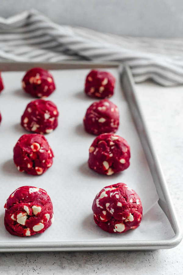 cookie dough balls on a parchment lined baking sheet