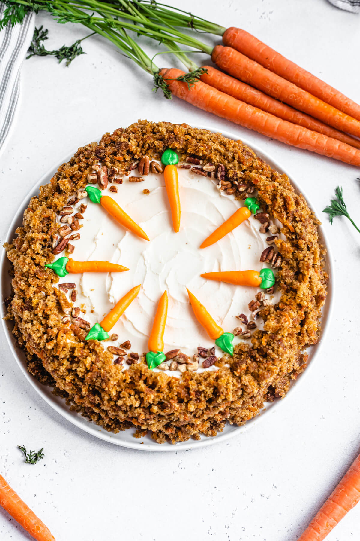 top view of cheesecake on a white plate with carrots around