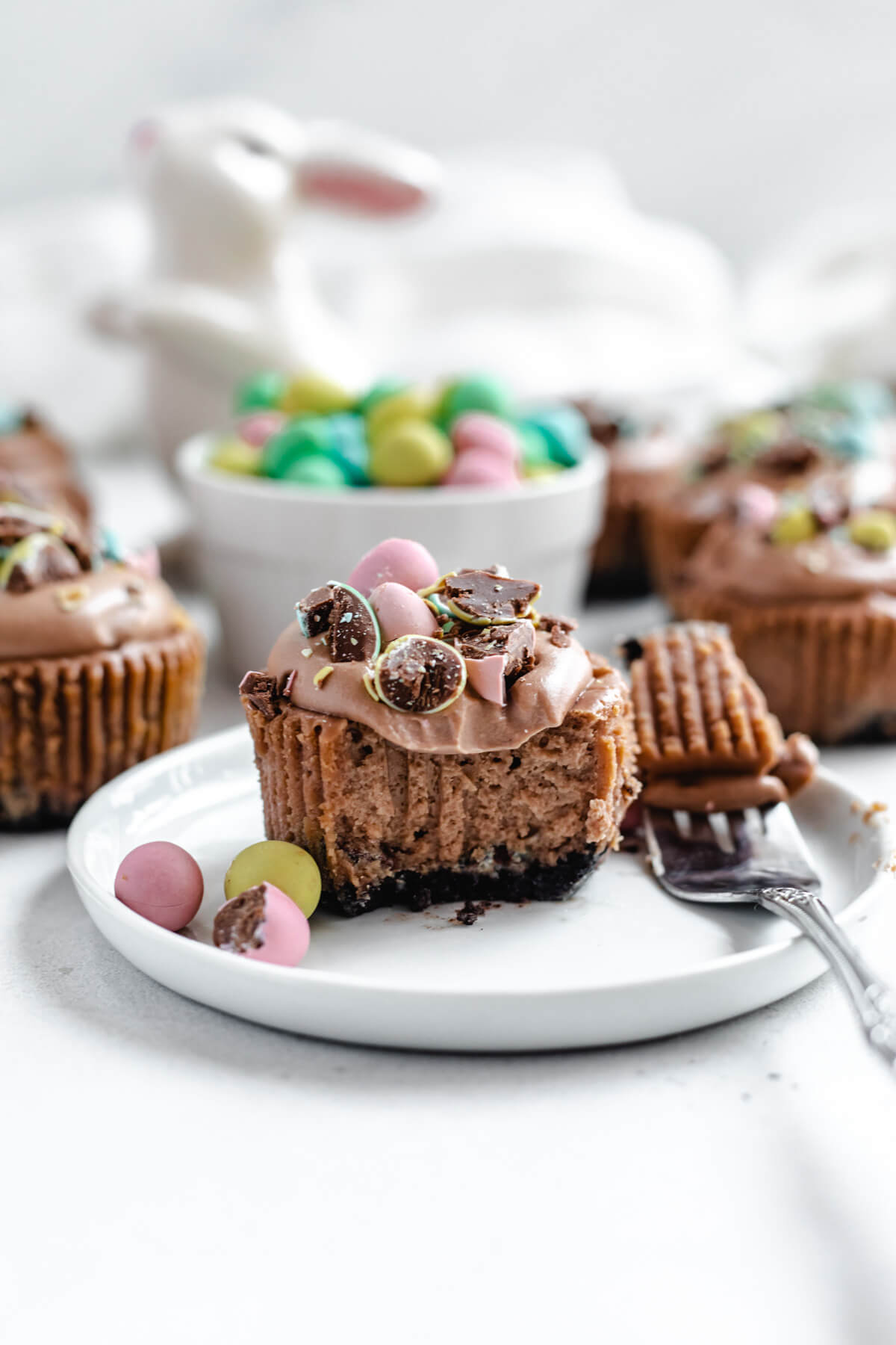 mini chocolate cheesecake on a small white plate with a bite taken out of it