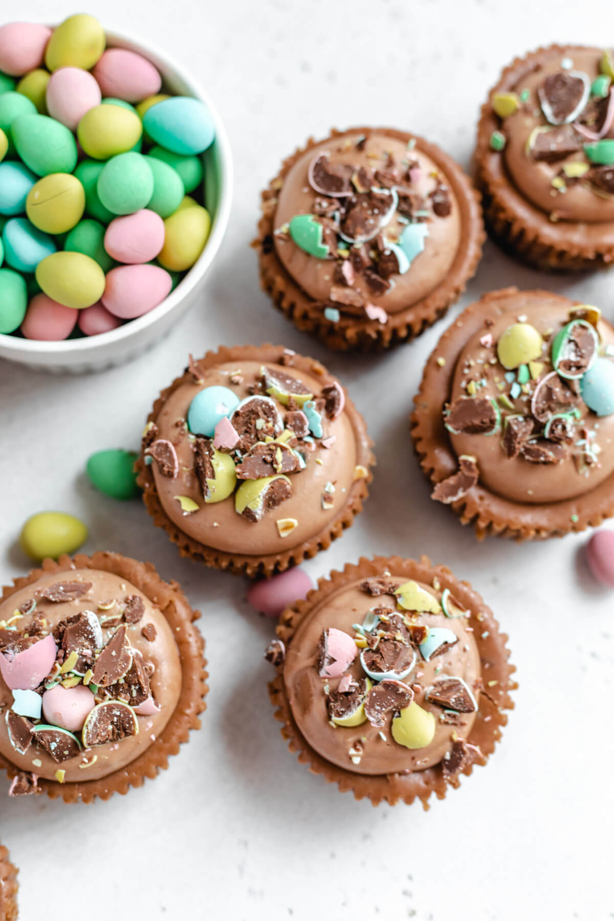 top view of small individual cheesecakes with mini chocolate eggs in a ramekin