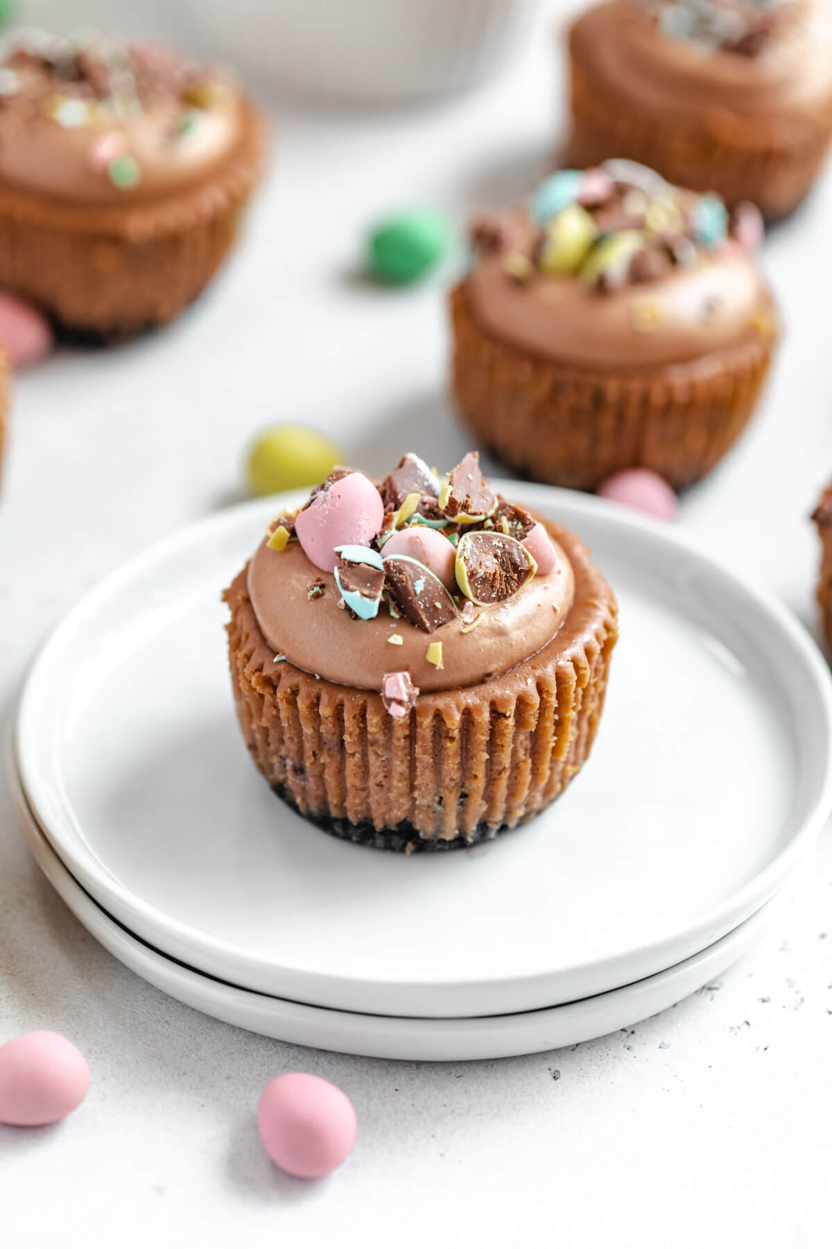 mini cheesecake cupcake on a stack of small white plates