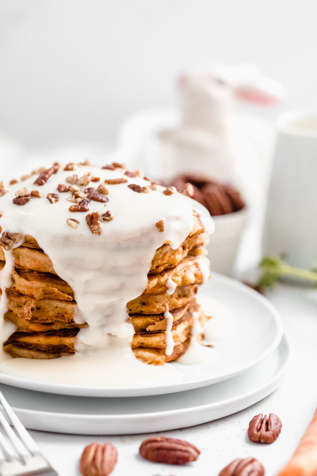 close up of a stack of pancakes on double white plates