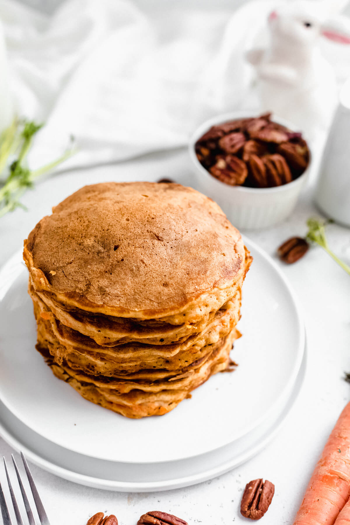 stack of carrot pancakes on a white plate 