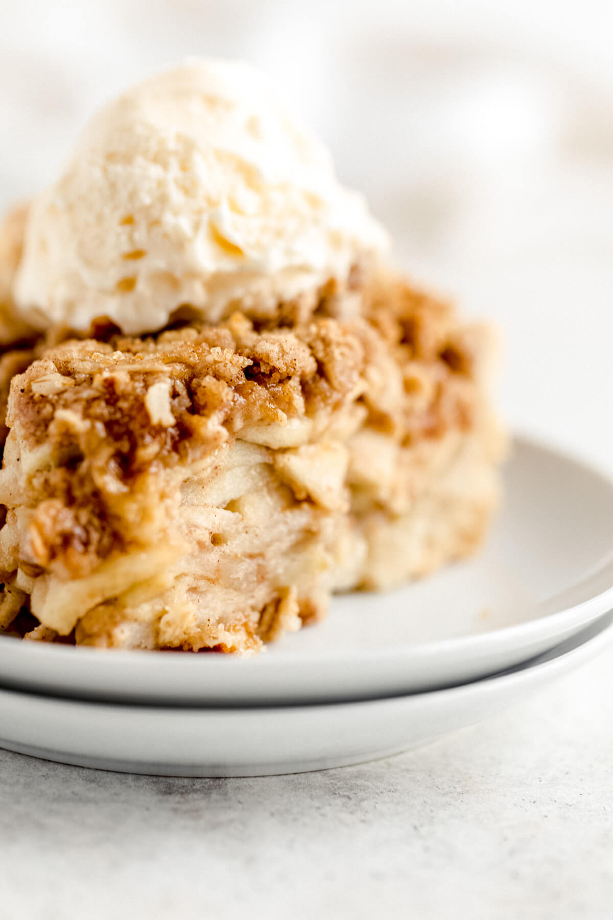 close up of ice cream topped pie on a double stacked white plate