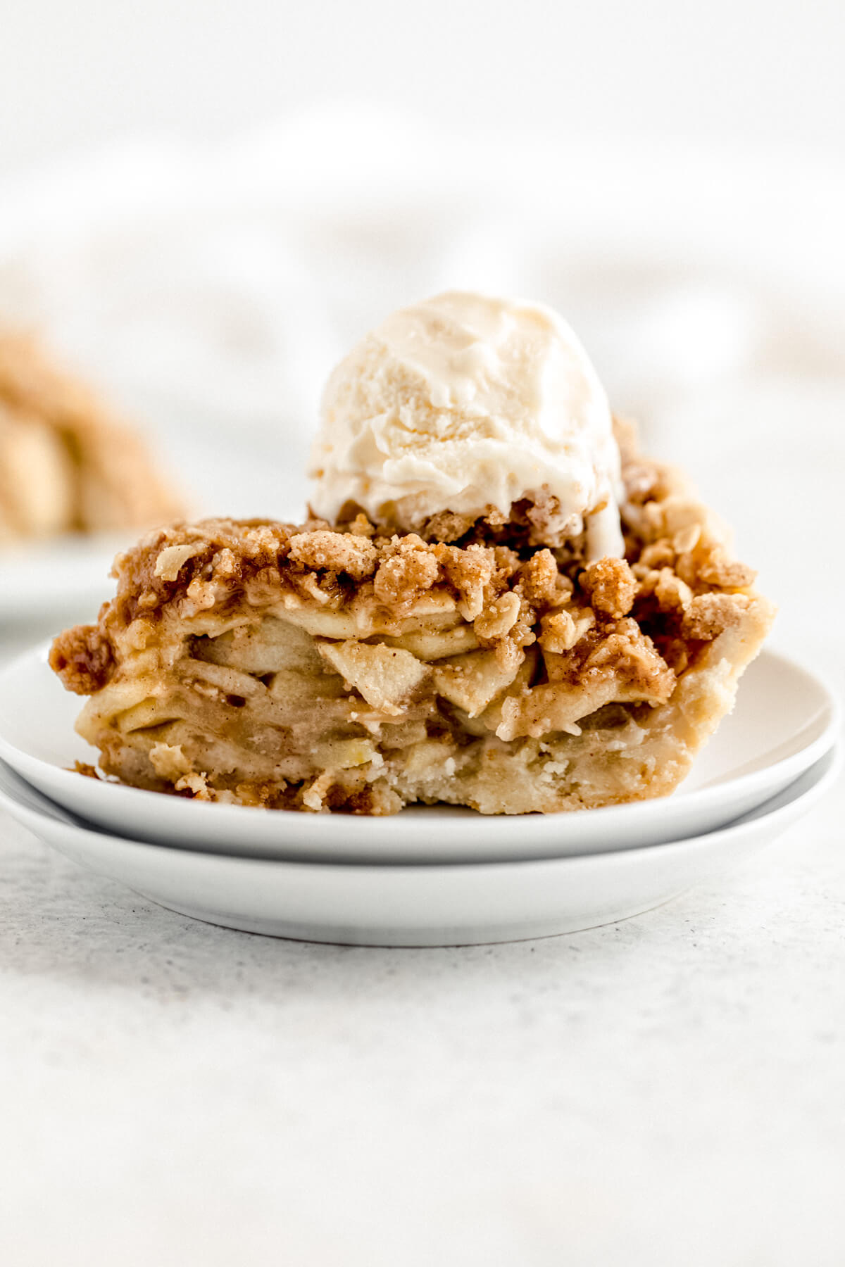 slice of apple pie topped with crumble and vanilla ice cream