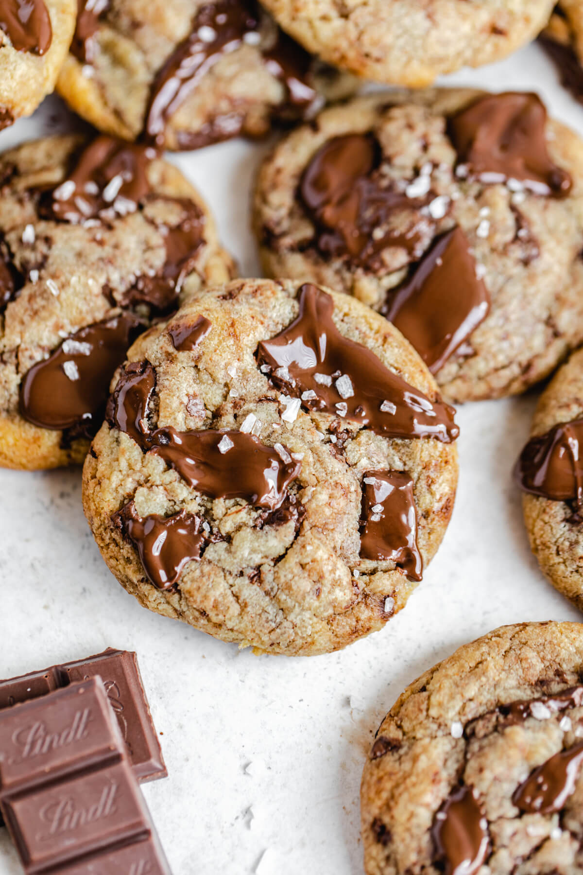 close up of brown butter cookies with pieces of chocolate beside them