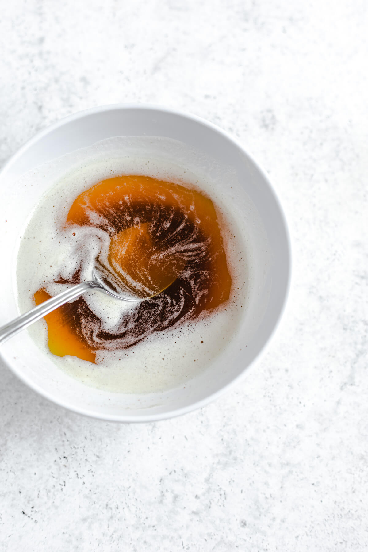 brown butter in a white bowl with a silver spoon