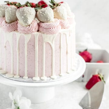 pink and white strawberry cake on a cake stand