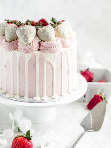 pink and white strawberry cake on a cake stand