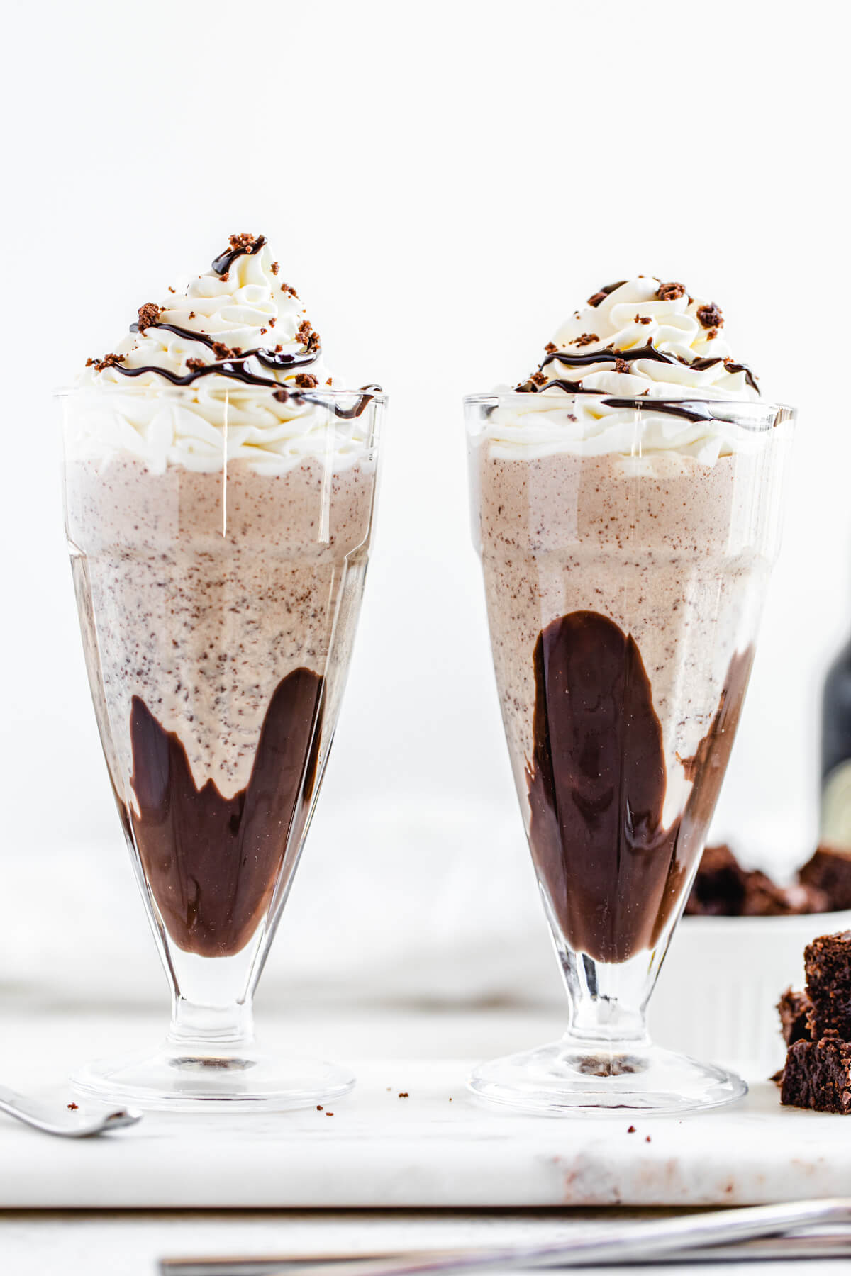 two glasses of milkshake on a marble board