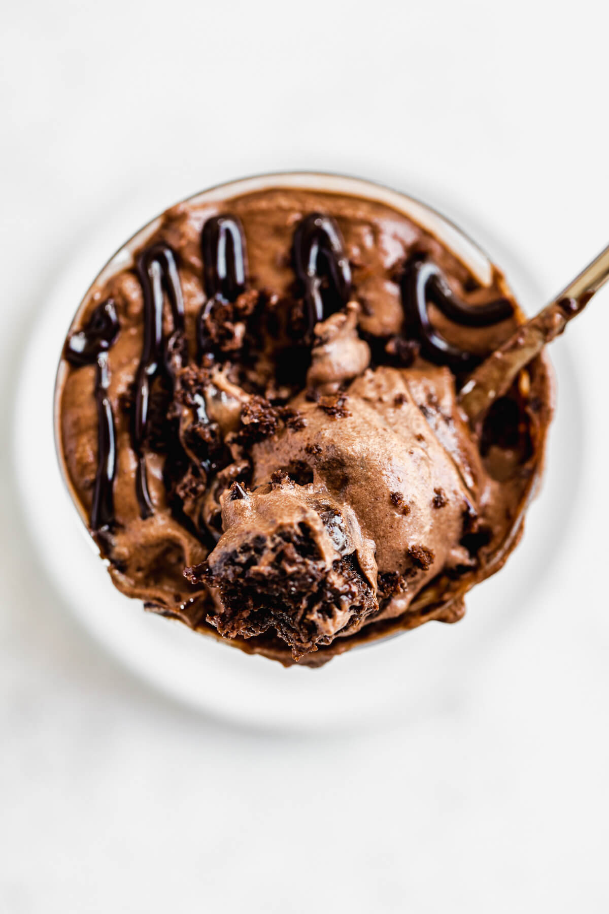 spoonful of mousse and brownie chunks laying on top of glass