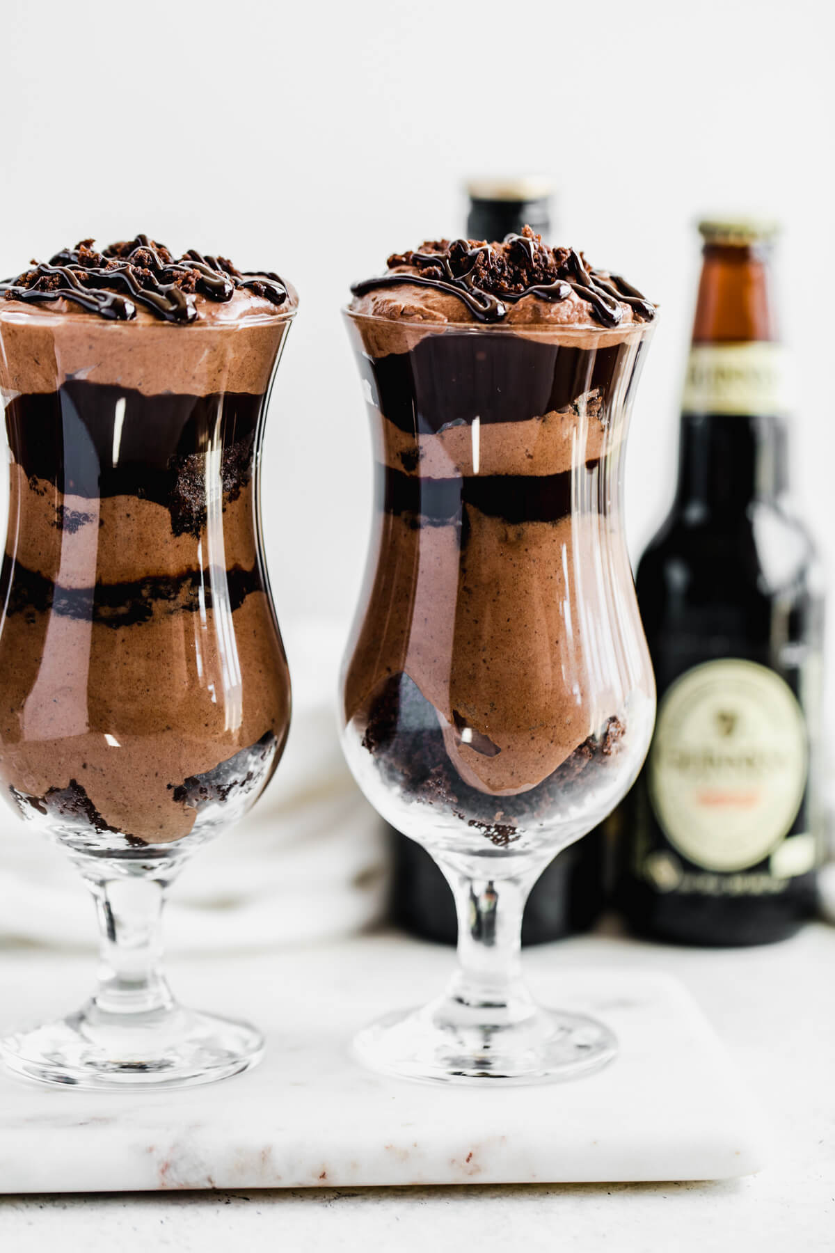 two large glasses filled with chocolate mousse, ganache and brownies