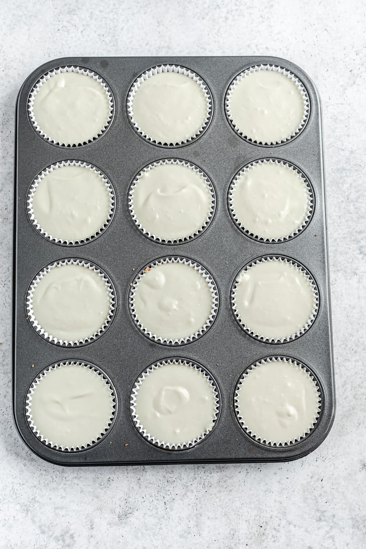 unbaked cheesecake batter in cupcake liners