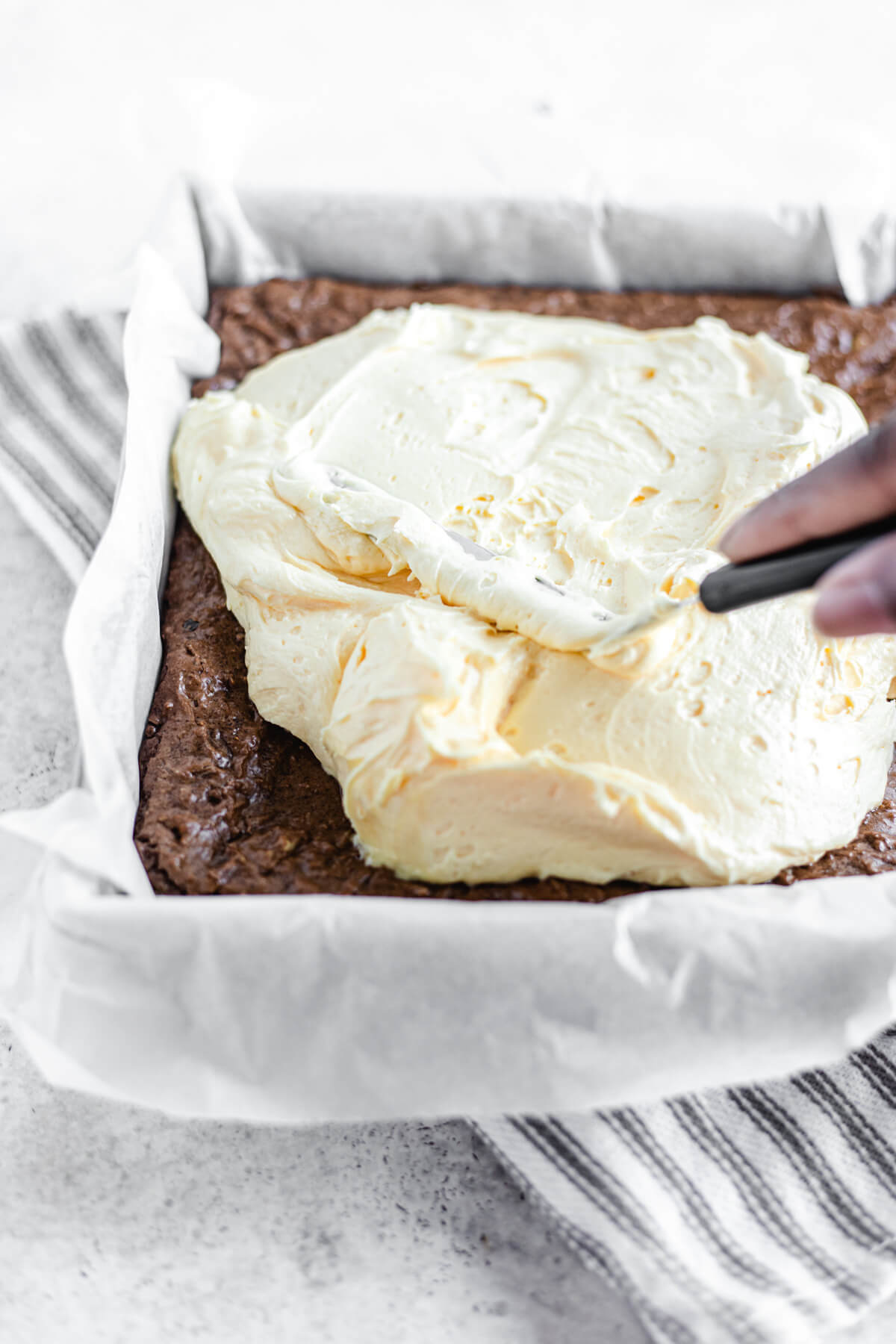 spreading custard buttercream onto brownies