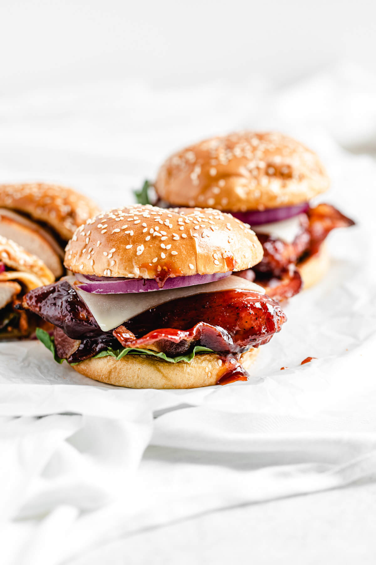 three chicken sandwiches on a large white plate