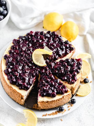 half sliced cheesecake on a white platter